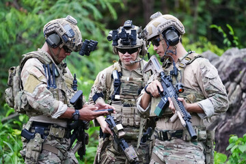 Military army soldiers tactical team, commando group moving cautiously in forest area, kneeling and...