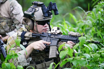 Military army soldiers tactical team, commando group moving cautiously in forest area, kneeling and...
