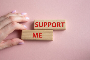 Support me symbol. Wooden blocks with words Support me. Businessman hand. Beautiful pink background. Business and Support me concept. Copy space.