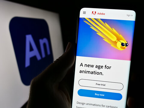 Stuttgart, Germany - 09-23-2023: Person holding cellphone with website of computer animation software Adobe Animate on screen in front of logo. Focus on center of phone display.