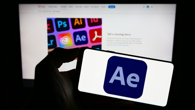 Stuttgart, Germany - 09-23-2023: Person holding mobile phone with logo of motion graphics software Adobe After Effects on screen in front of web page. Focus on phone display.