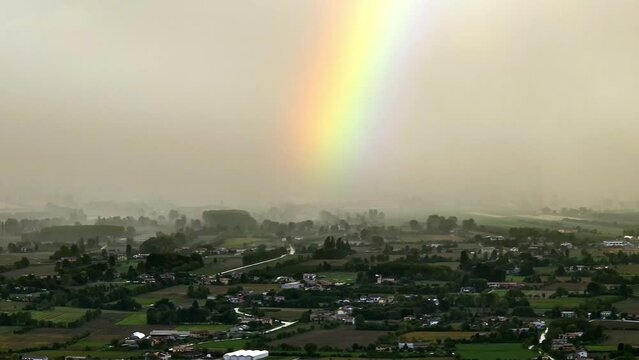 Aerial Italy: Road meets tempest, adorned with a rainbow.



