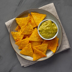 Homemade Guacamole with Tortilla Chips on a Plate, top view. Flat lay, overhead, from above.