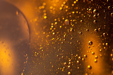 Oil in water, abstract background in golden color tones