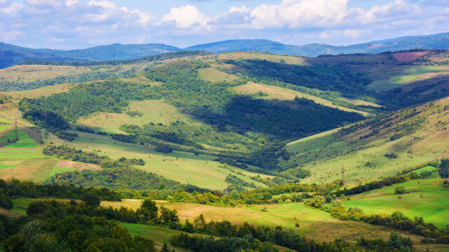 rural landscape of carpathian mountains. beautiful countryside scenery in autumn season with fields on the hills in the valley