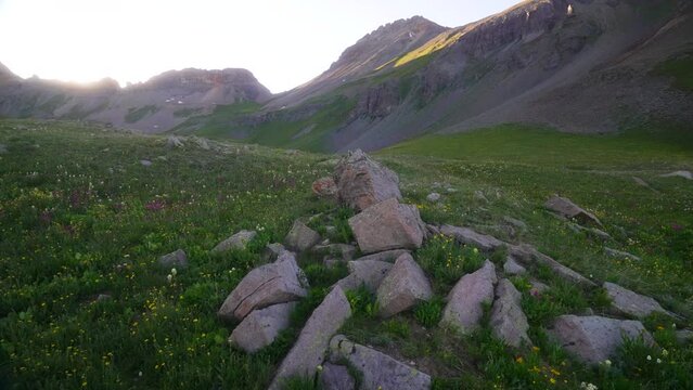 Cinematic pan left slowly  stunning colorful wildflower Colombine Colorado last Dusk sunset golden hour light Ice Lake Basin Silverton Telluride Ouray Trailhead top of peak Rocky Mountains landscape