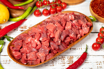 Beef cubed on wood background. Raw beef cubed with herbs and spices