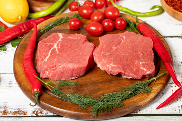 Beef round slice on wood background. Raw beef round with herbs and spices