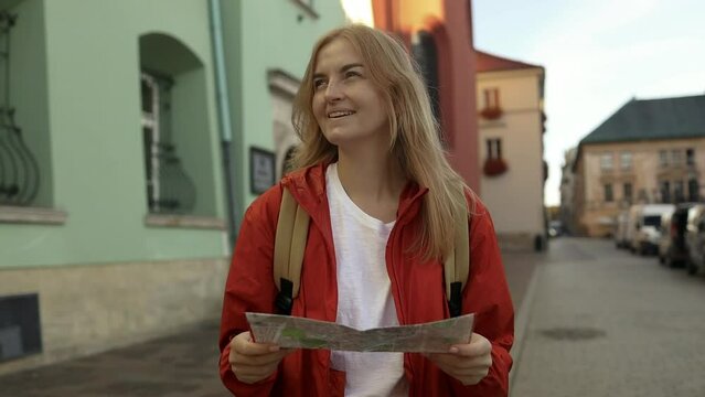 Real view of lost traveller woman walking on old Market Square in Krakow holding tourist map. Travel and active lifestyle concept. High quality FullHD footage
