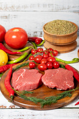 Beef round slice on wood background. Raw beef round with herbs and spices