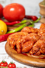 Chicken tenderloin on wood background. Raw chicken tenderloin with herbs and spices