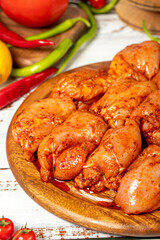 Chicken tenderloin on wood background. Raw chicken tenderloin with herbs and spices