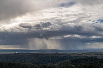 Sun rays shining through rainclouds showing the falling rain in Northern Israel looking towards the...