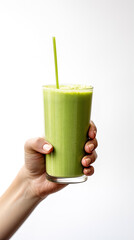 Hand holds a glass of fresh green smoothie. Summer drink milkshake and refreshment organic concept