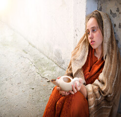 Girl with an empty lamp sits on the ground