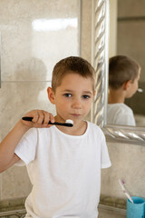 Little boy in white t-shirt brushing his teeth.Milk teeth are replaced by molars