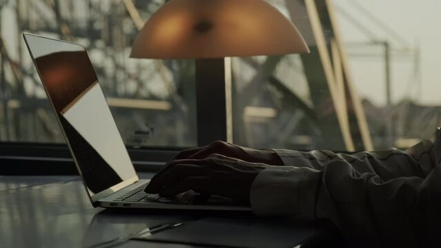 Close up view of Woman works on laptop while riding train sitting near window on sunny day