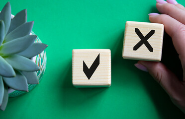 Yes vs No symbol. Businessman hand is making a choice between YES and No symbol. Beautiful green background with succulent plant. Business concept. Copy space.