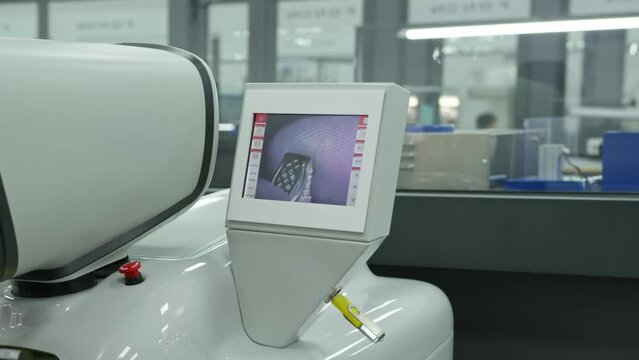 A young man works with small jewelry details under a microscope