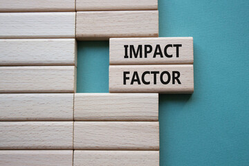 Impact Factor symbol. Wooden blocks with words Impact Factor. Beautiful grey green background. Business and Impact Factor concept. Copy space.