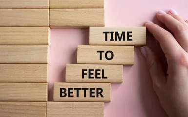 Foto op Plexiglas Time to feel better symbol. Wooden blocks with words Time to feel better. Businessman hand. Beautiful pink background. Medicine and Time to feel better concept. Copy space. © Natallia