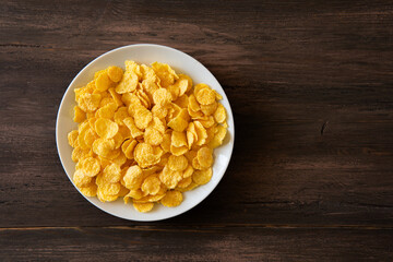 Corn flakes served on wooden table.