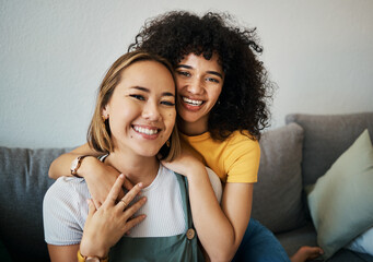 Lesbian, couple and portrait of hug on sofa in home, living room or apartment with love, support and happiness. Lgbt, women and embrace together with smile on face on lounge, relax and couch in house