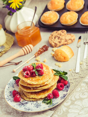 Stack of sweet pancakes with raspberries on table