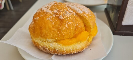 A cream-filled pastry, known as a "bomba de crema", displayed for dessert.