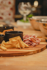 Wooden cutting board with cheese and Prosciutto