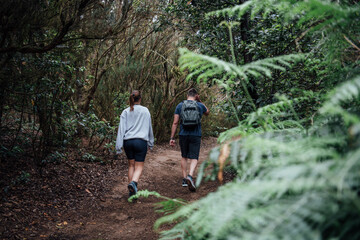 Obraz premium A young sporty couple walks along a path through the forest in Tenerife