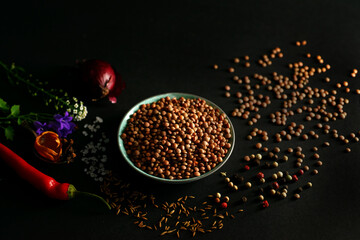 Lentils and herbs for an Indian dal, on a black background