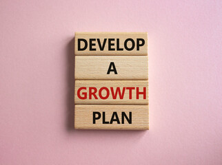 Develop a growth mindset symbol. Wooden blocks with words Develop a growth mindset. Beautiful pink background. Business concept. Copy space