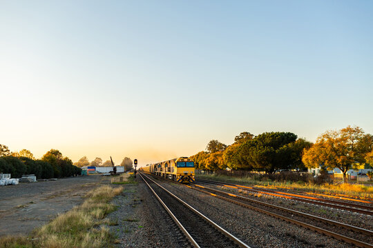 Coal train approaching to pass station in Singleton in morning light