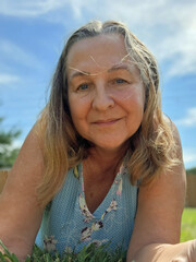 senior adult woman portrait laying in grass