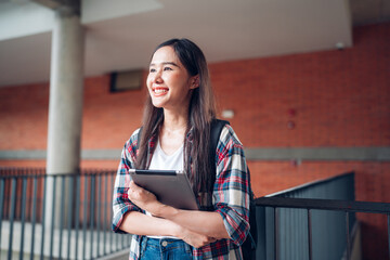 Cheerful Female Student With tablet Standing Outdoors, Happy Young Asian Woman Walking In City After College Classes, Looking Away And Smiling.