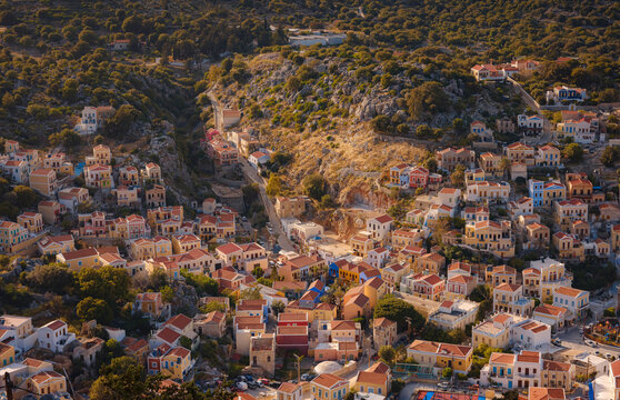 Symi Island, Greece. Greece islands holidays from Rhodos in Aegean Sea. Colorful neoclassical beautiful houses on hillsides of a Greek island during sunset. Holiday travel background.