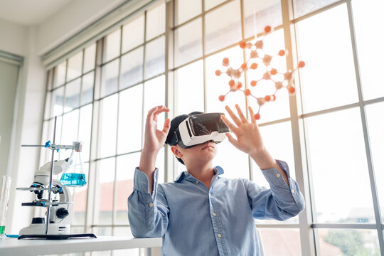 Boy having fun time with using VR glasses holding molecular model learning chemistry science at classroom. Science Laboratory.