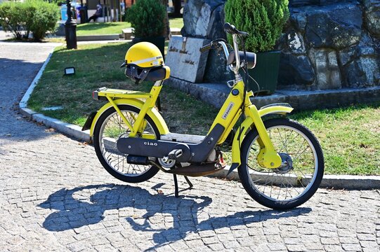Vintage restored yellow Ciao Piaggio scooter parked downtown