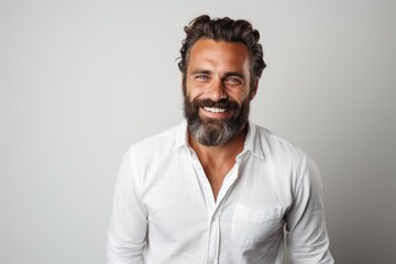 Obraz premium Portrait of a handsome man smiling and looking at the camera on a gray background. Generative Ai