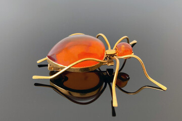 vintage brooch "Ant" with of amber and brass, made in USSR on dark glossy background
