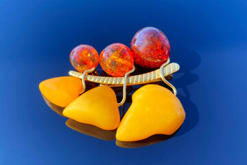 vintage brooch berries and leaves with of amber and brass, made in USSR on blue glossy background