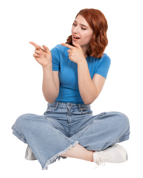 Point away aside with both fore fingers,  full body view caucasian red bob hair young woman point away aside with both fore fingers. Sit floor, showing, looking copy space. Advertisement concept.