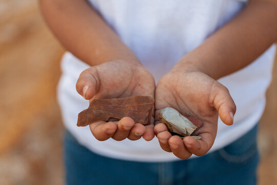 First Nation Australian child holding aboriginal artefact stones in hands