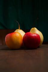 red pears and apples on a wooden base