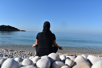 woman meditating on the beach