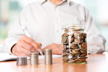 The coins are stored in a glass jar to accumulate finances.