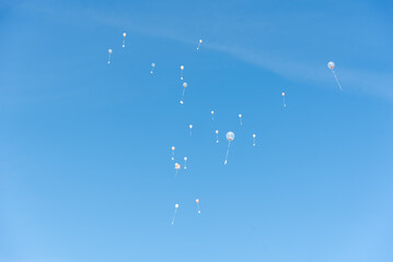many white balloons flying in the air