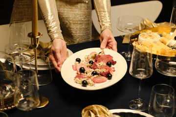 High angle shot of woman preparing to celebrate Christmas setting dining table with delicious meal