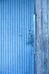 Old blue wood door with door handle and lock.